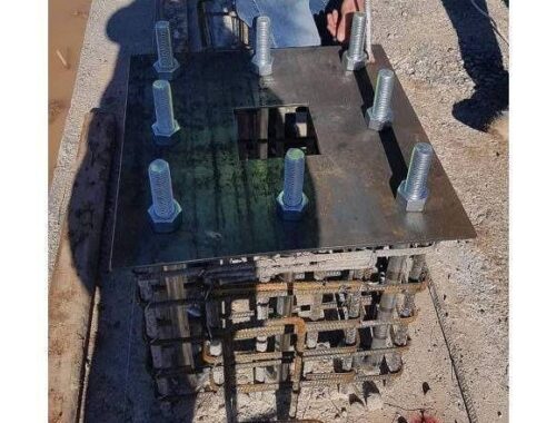 Steel anchor plate with multiple bolts and exposed reinforcement beneath
