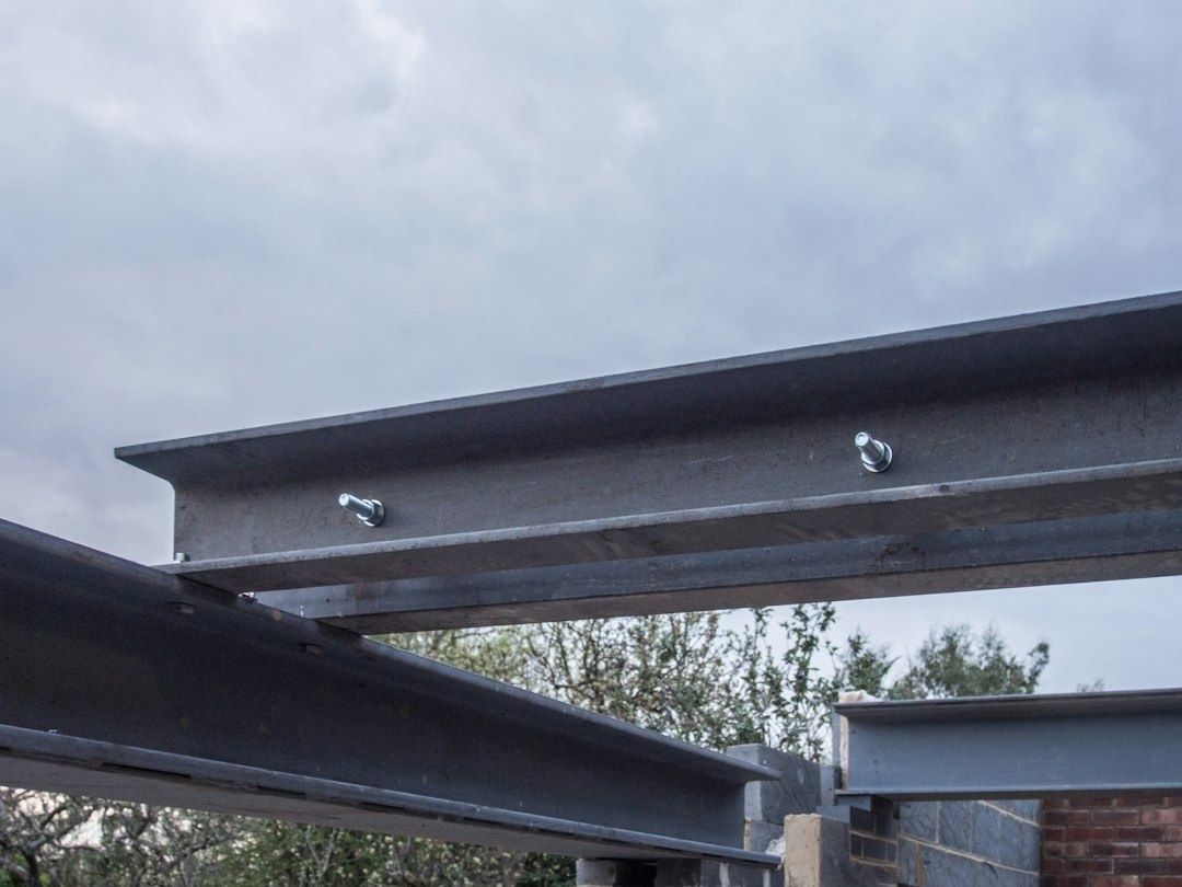 Galvanized steel beams and bolts forming an outdoor structural frame
